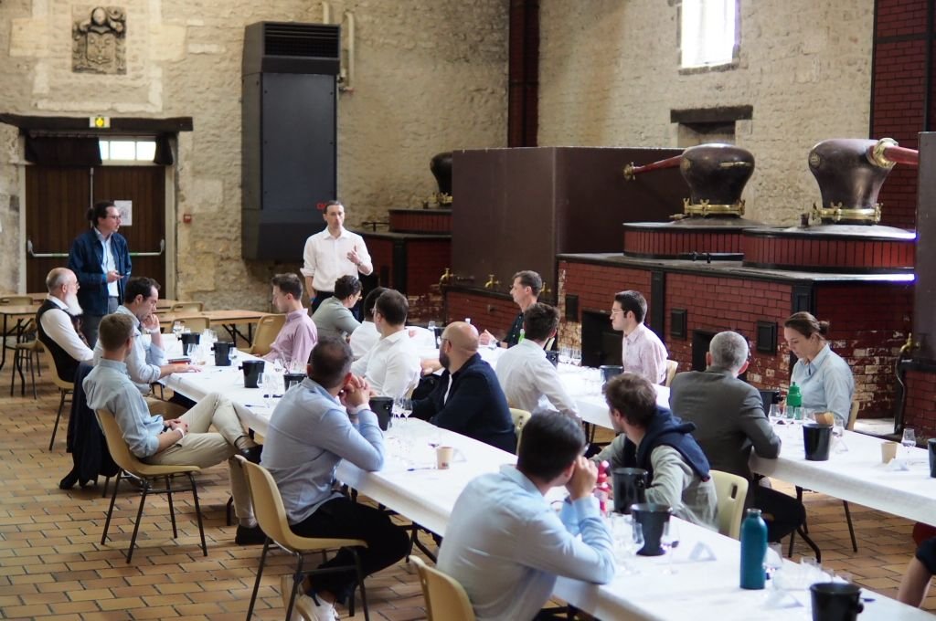 Les candidats aux tables de dégustation, devant les alambics du CIDS
